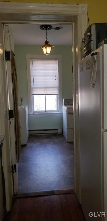 kitchen featuring washer / clothes dryer, dark wood-type flooring, stainless steel refrigerator, and a baseboard heating unit