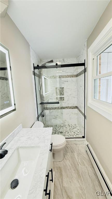 bathroom with walk in shower, vanity, toilet, and a baseboard heating unit