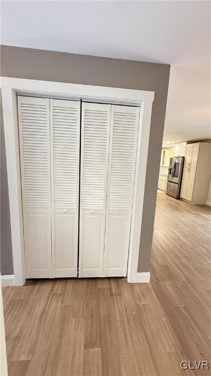 interior details featuring hardwood / wood-style flooring and stainless steel fridge with ice dispenser