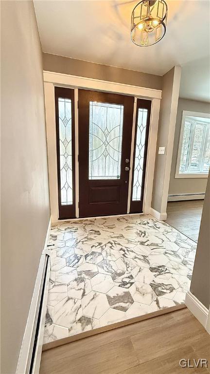 foyer entrance with hardwood / wood-style floors and baseboard heating