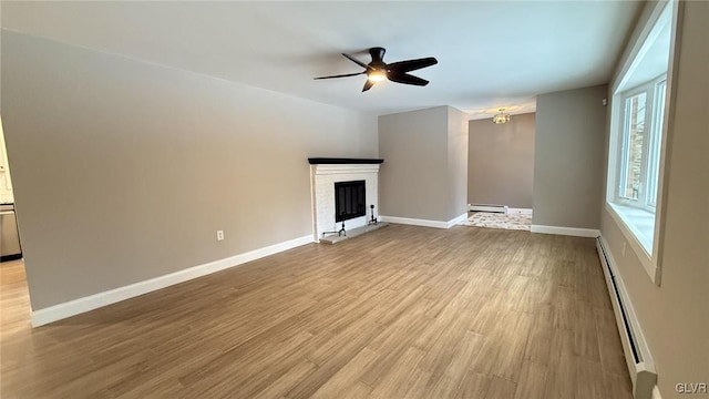 unfurnished living room featuring a baseboard heating unit, light hardwood / wood-style flooring, a brick fireplace, and ceiling fan