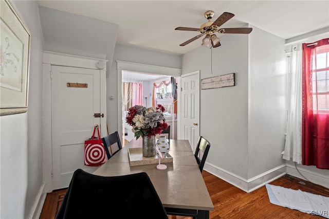 dining space with hardwood / wood-style floors and ceiling fan