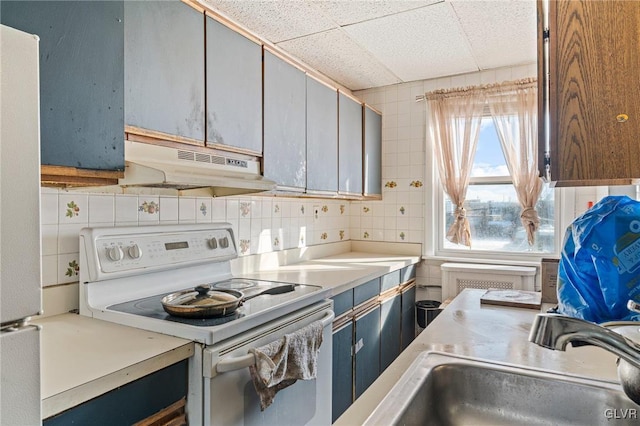 kitchen featuring a drop ceiling, backsplash, sink, and white electric range oven