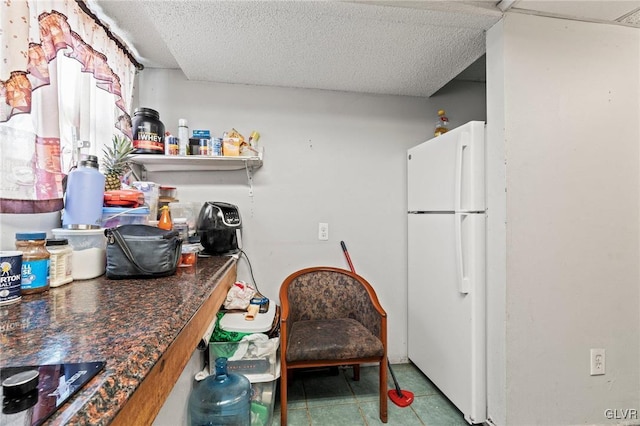 kitchen with black electric cooktop, a textured ceiling, and white fridge