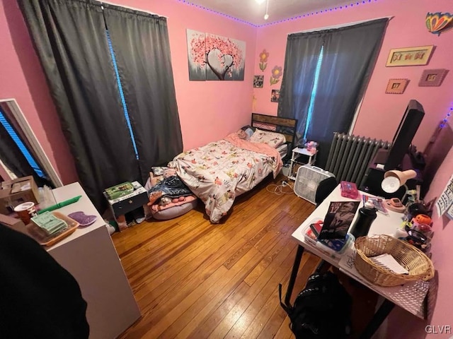 bedroom with hardwood / wood-style floors and radiator