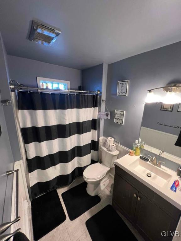 bathroom with a shower with curtain, tile patterned floors, vanity, and toilet