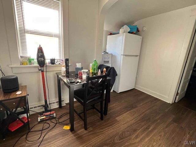 dining area featuring dark wood-type flooring and a baseboard radiator