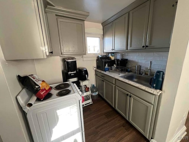 kitchen with white electric range, tasteful backsplash, sink, gray cabinetry, and dark wood-type flooring