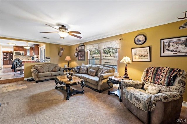 living room with ornamental molding, carpet, and ceiling fan