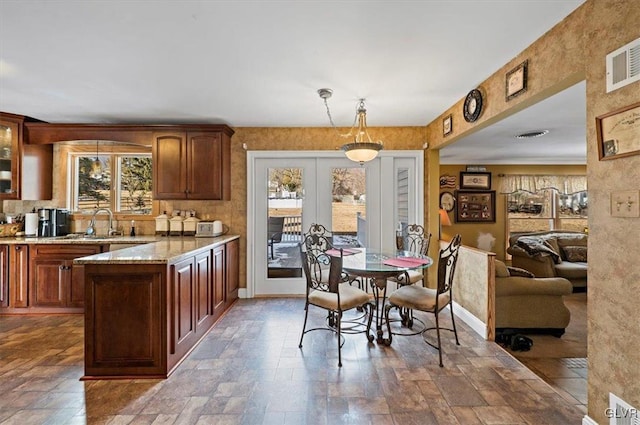 kitchen with decorative light fixtures, light stone countertops, and french doors