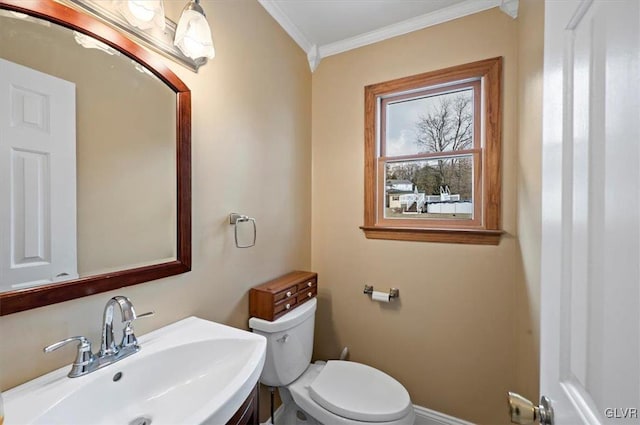 bathroom with ornamental molding, sink, and toilet