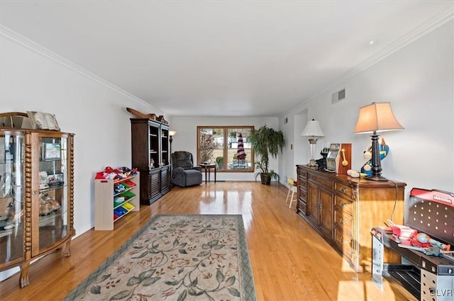 living room featuring crown molding and light hardwood / wood-style floors