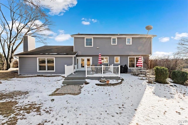 snow covered rear of property featuring a wooden deck