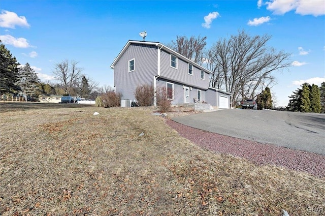 view of property exterior featuring a garage and a lawn