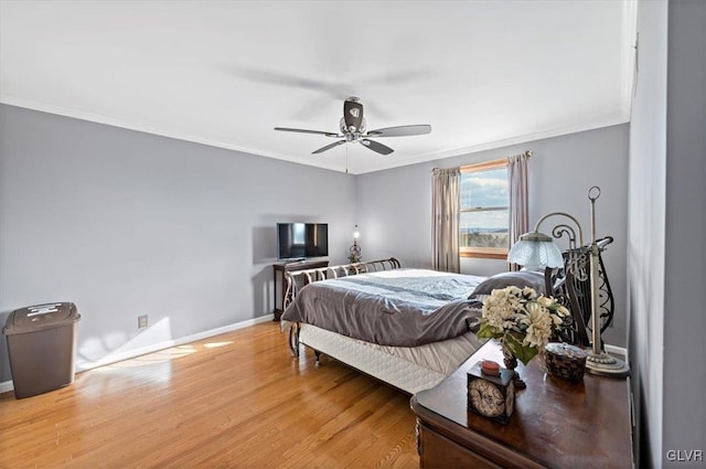 bedroom with crown molding, ceiling fan, and wood-type flooring