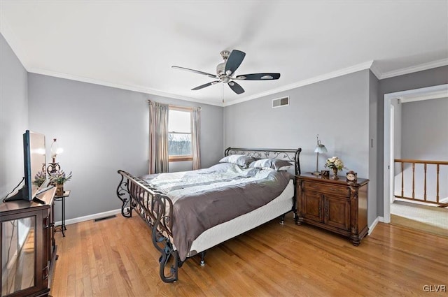 bedroom with crown molding, light hardwood / wood-style floors, and ceiling fan