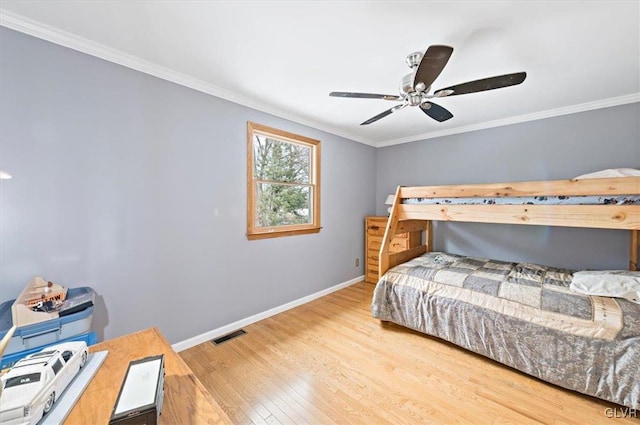 bedroom with hardwood / wood-style flooring, ornamental molding, and ceiling fan