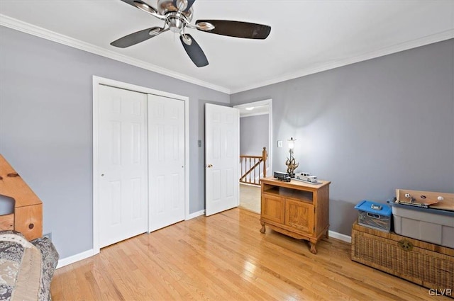 bedroom with hardwood / wood-style floors, ornamental molding, a closet, and ceiling fan