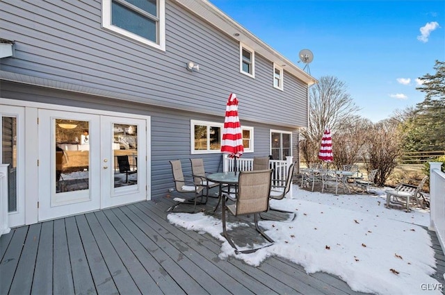 snow covered deck featuring french doors