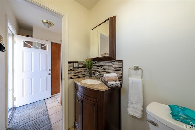 bathroom with tile patterned floors, vanity, toilet, and backsplash