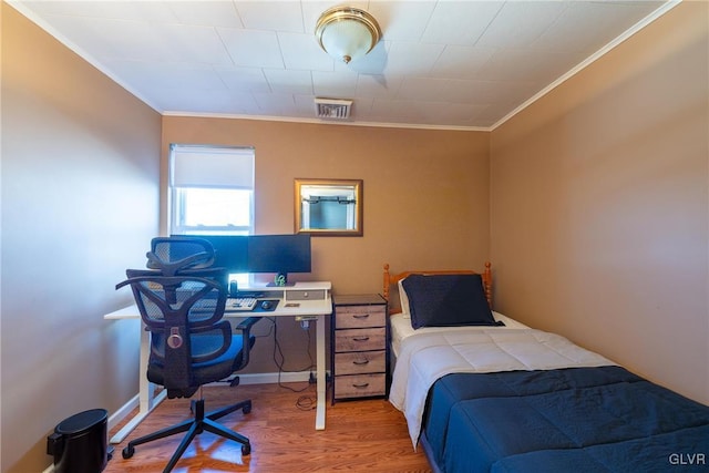 bedroom with hardwood / wood-style flooring and crown molding