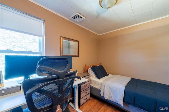 bedroom with crown molding and wood-type flooring