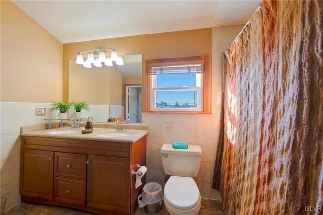 bathroom with vanity, toilet, and tile walls