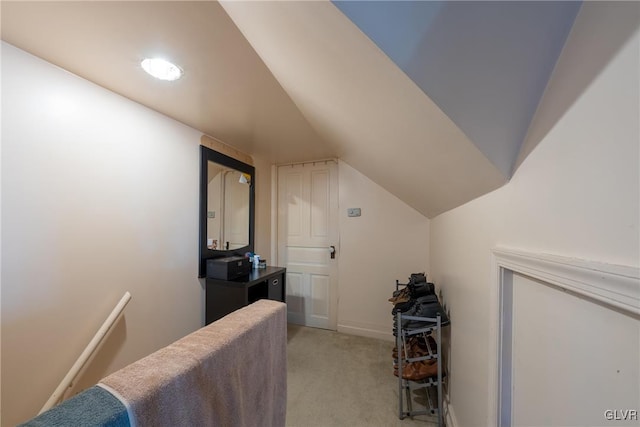 interior space featuring light carpet and vaulted ceiling