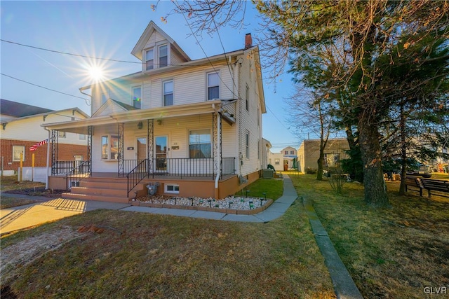 view of front of property featuring a front yard and covered porch