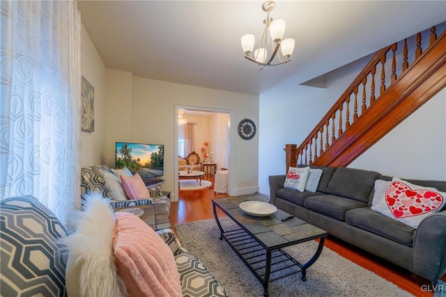 living room with hardwood / wood-style flooring and a notable chandelier