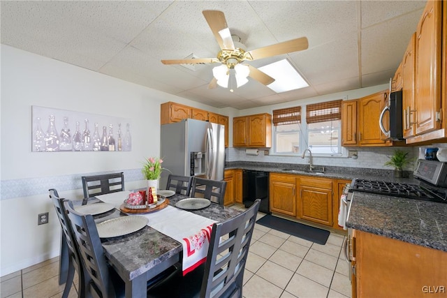 kitchen featuring sink, ceiling fan, backsplash, stainless steel appliances, and light tile patterned flooring