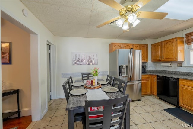 kitchen with light tile patterned floors, stainless steel fridge, dishwasher, tasteful backsplash, and a drop ceiling