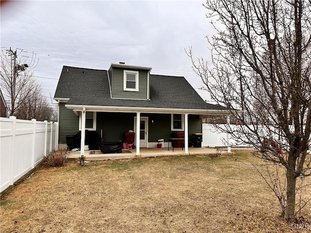 back of house featuring a lawn and a patio