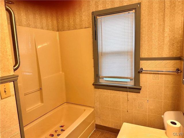 bathroom featuring shower / bathing tub combination and tile walls