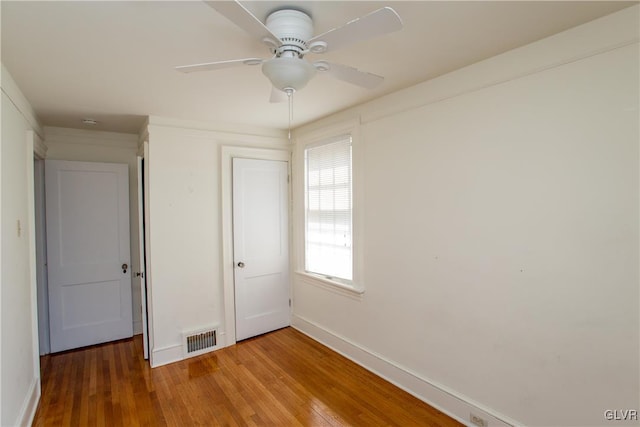 unfurnished bedroom featuring hardwood / wood-style floors, a closet, and ceiling fan