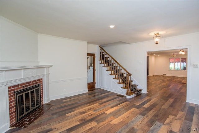 unfurnished living room with ornamental molding, dark hardwood / wood-style floors, and a fireplace