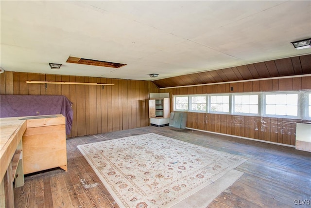 bedroom with dark hardwood / wood-style flooring and wood walls