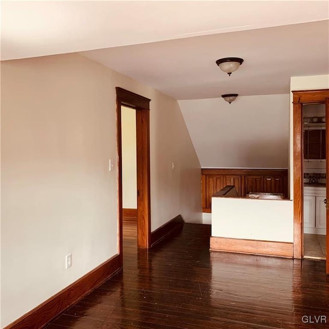 additional living space with dark hardwood / wood-style floors and vaulted ceiling