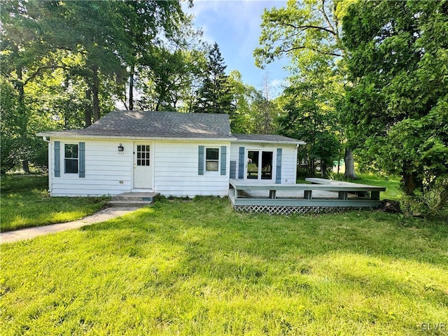 rear view of house with a deck and a lawn