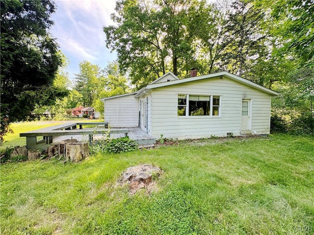 back of house featuring a wooden deck and a yard