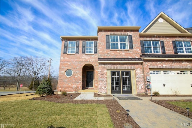 townhome / multi-family property featuring a garage and a front yard