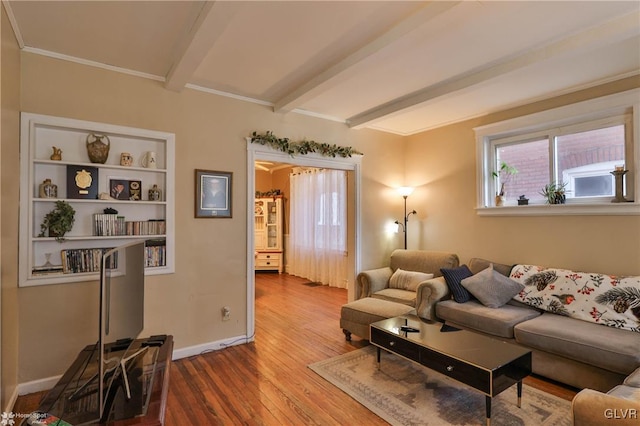 living room with beamed ceiling, ornamental molding, and hardwood / wood-style floors