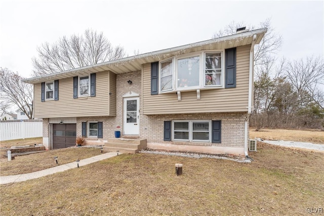 bi-level home featuring a garage and a front yard