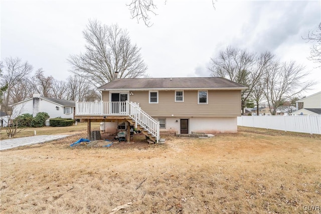 rear view of property with a wooden deck, central AC unit, and a lawn