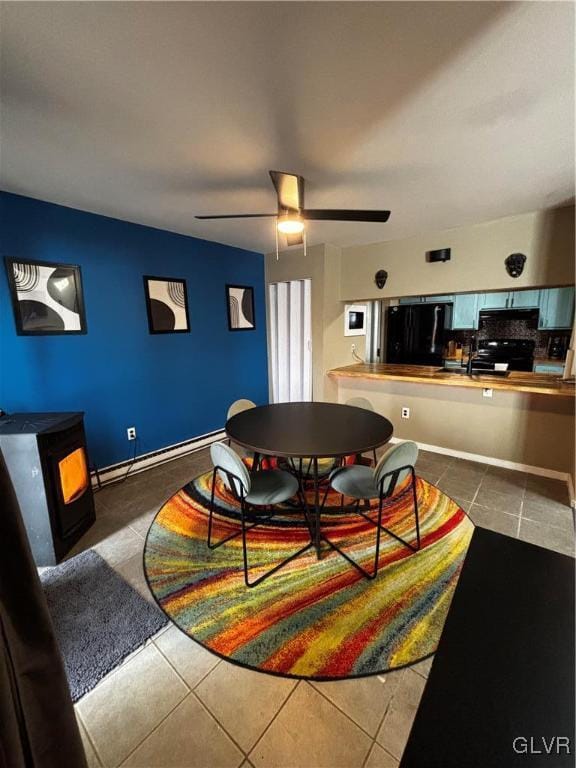 tiled dining room with a baseboard radiator and ceiling fan