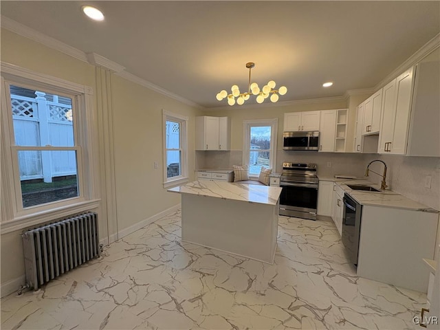 kitchen featuring decorative light fixtures, appliances with stainless steel finishes, radiator, light stone countertops, and white cabinets