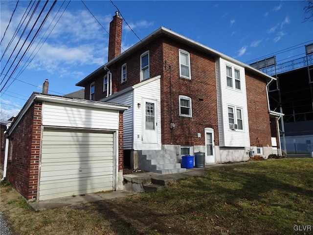 back of house with a garage and a lawn