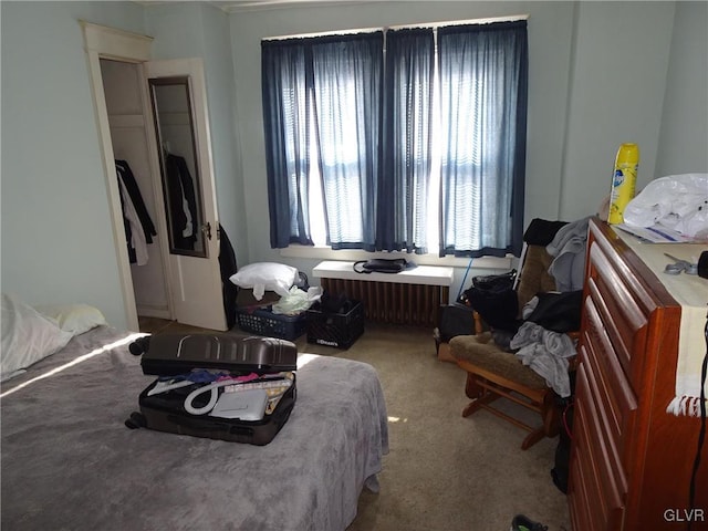 bedroom with radiator heating unit and carpet