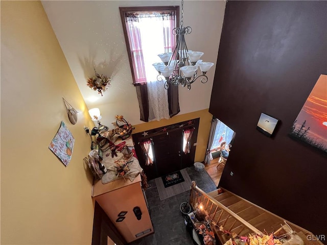 entryway with an inviting chandelier and a towering ceiling