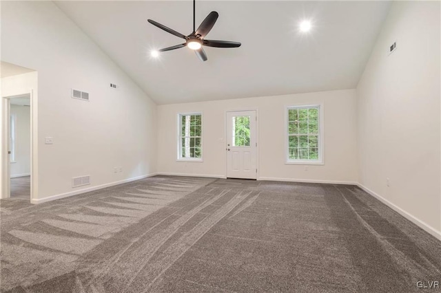 unfurnished living room with dark carpet, plenty of natural light, high vaulted ceiling, and ceiling fan